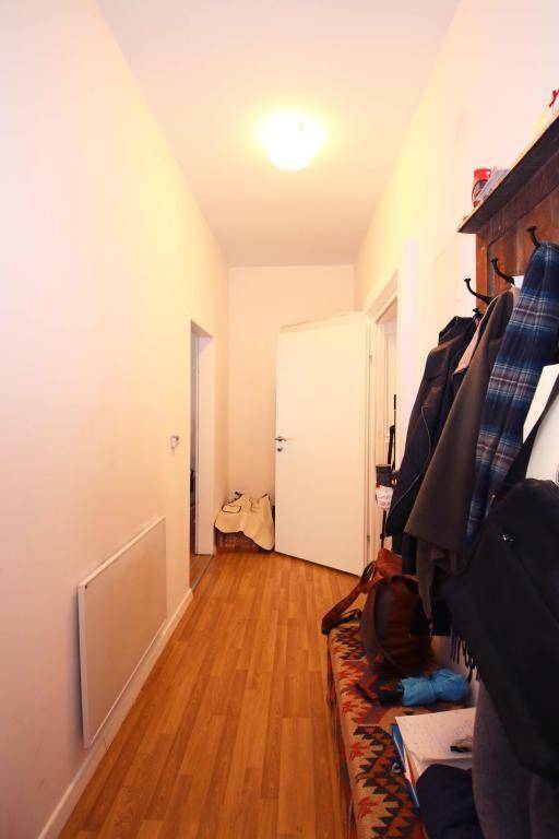 Heller Flur mit Holzfußboden, Garderobe und Zugang zu weiteren Räumen.