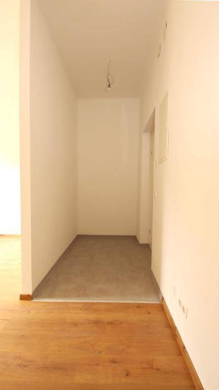 Heller Flur mit Laminatboden, der zu weiteren Räumen führt, in neuwertigem Zustand.