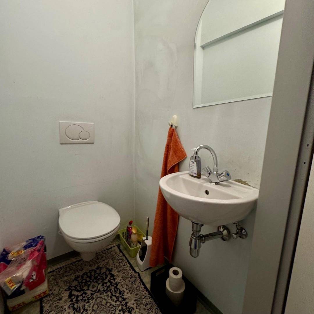 Kleines Gäste-WC mit Toilette und Handwaschbecken in hellblauer Farbgebung für Besucher.