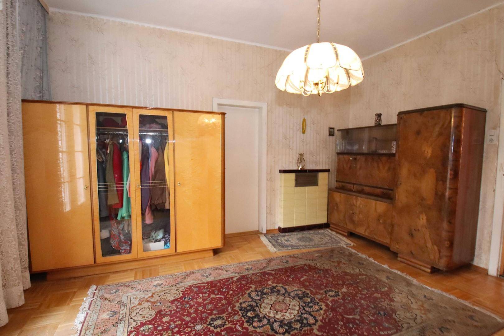 Schlafzimmer mit zwei großen Holzschränken, Parkettboden und einem traditionellen Teppich.