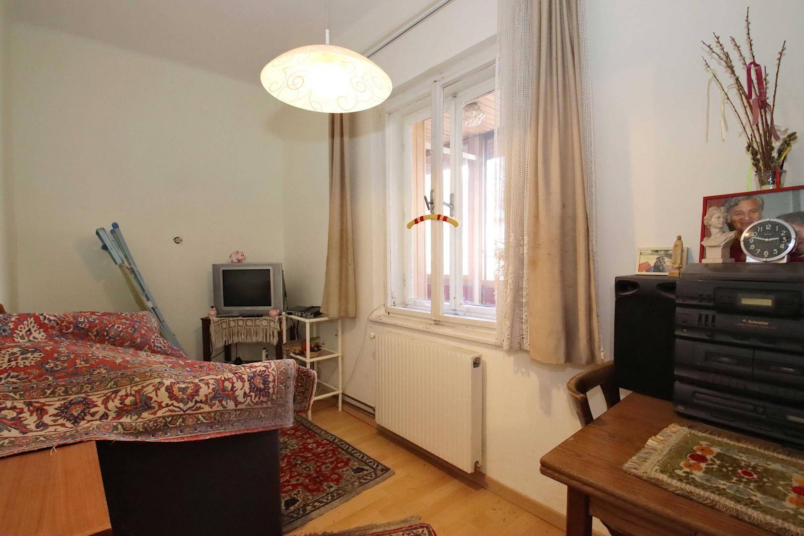 Kleines Schlafzimmer mit Einzelbett, Teppich und Fenster.