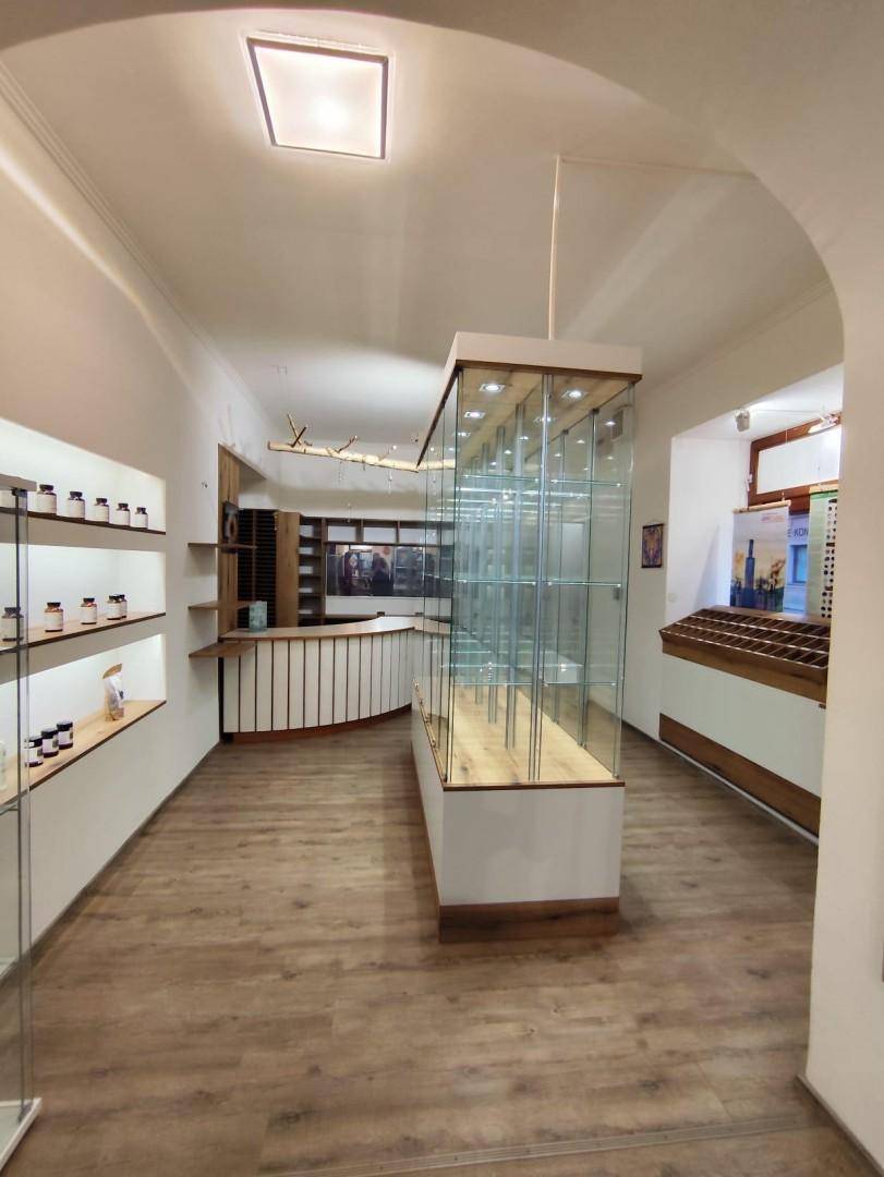 Gewerbefläche mit modernen Glasvitrinen, einer geschwungenen Theke und Regalen entlang der Wände.