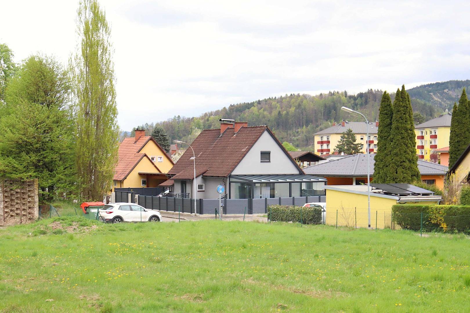 Gesamtansicht des Hauses in einer Wohnsiedlung mit umliegender grüner Landschaft.