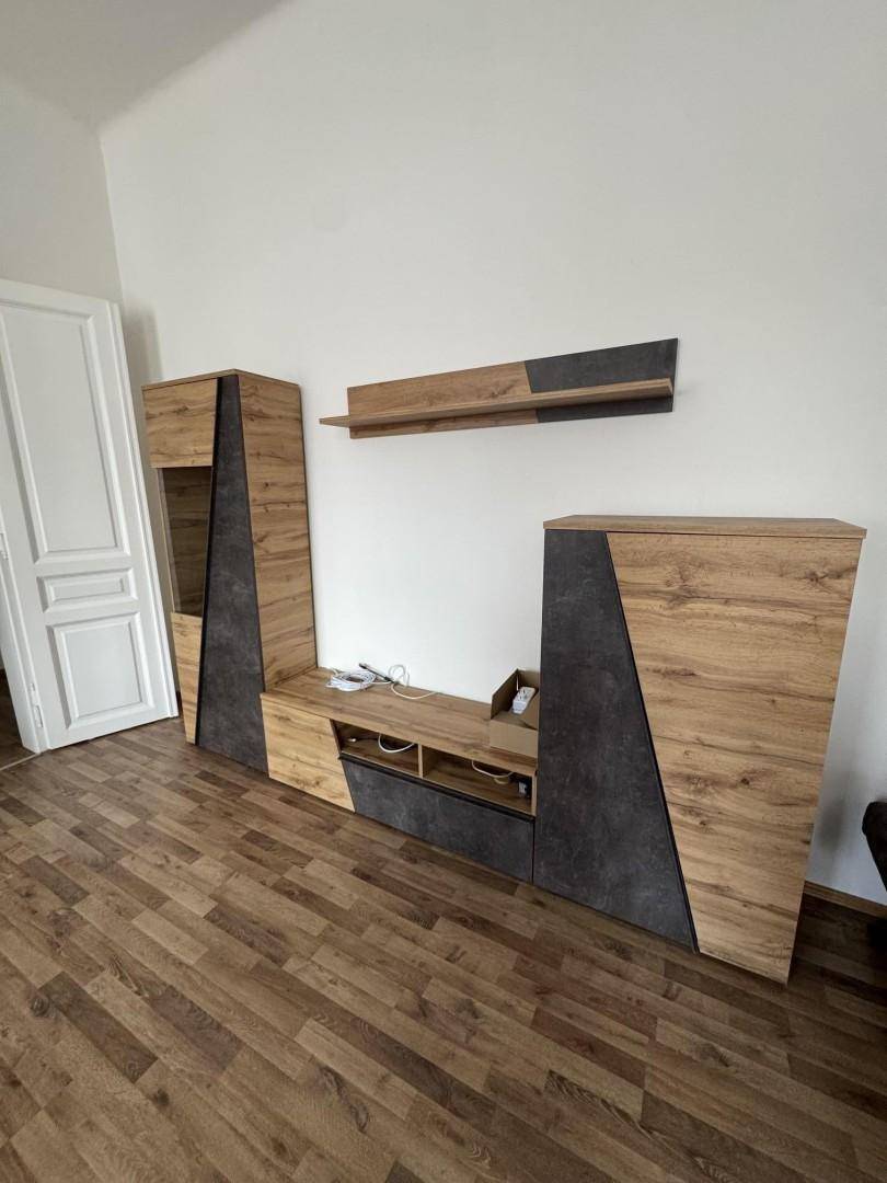 Wohnzimmer mit modernem TV-Möbel in Holzoptik und Laminatboden.