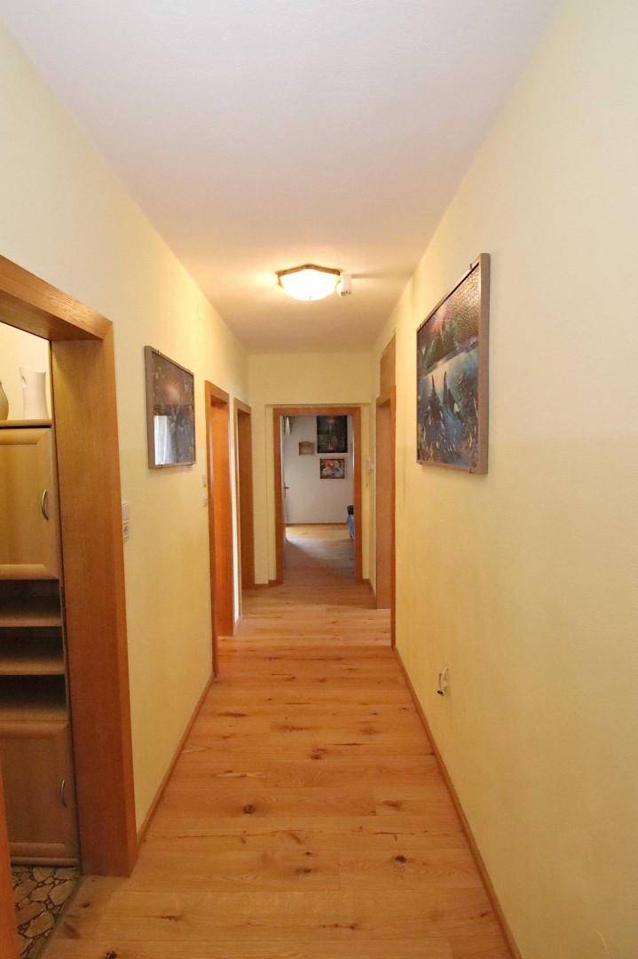 Heller Flur mit Holzfußboden und mehreren Türen, der zu weiteren Räumen führt.