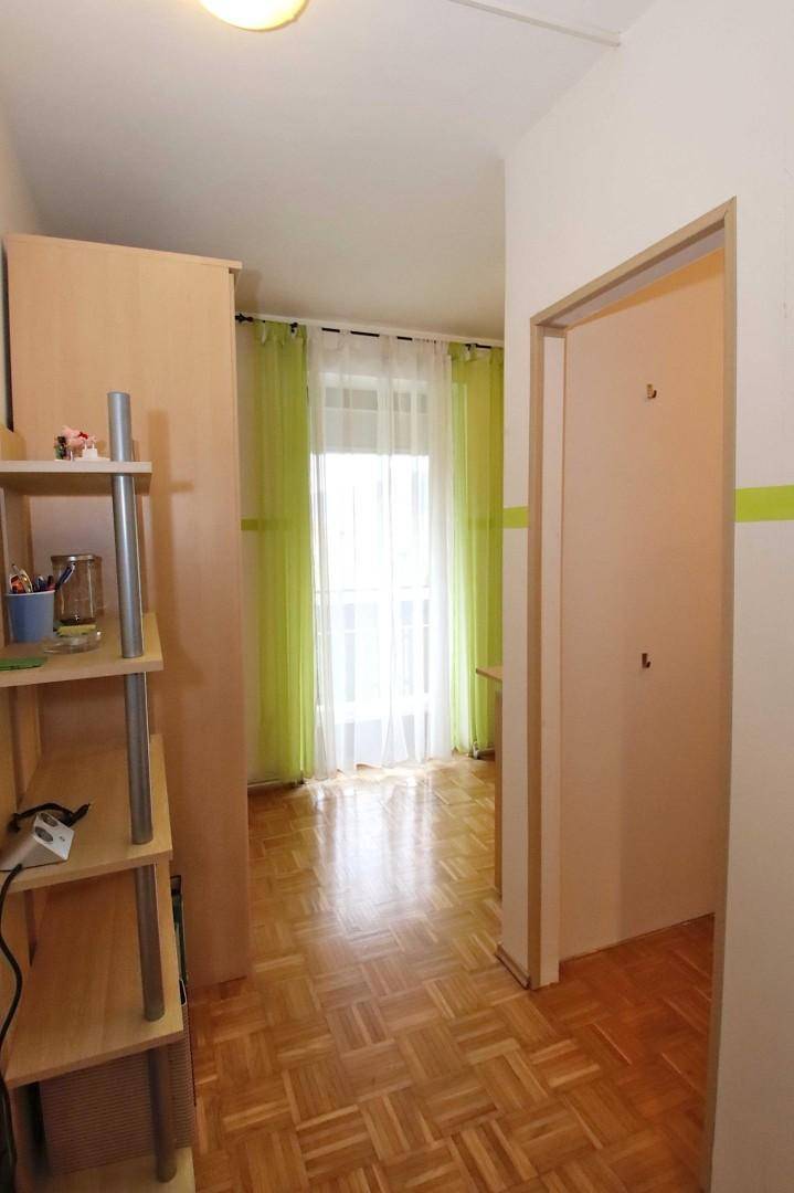 Heller Flur mit Parkettboden und einem Blick in ein angrenzendes Zimmer.