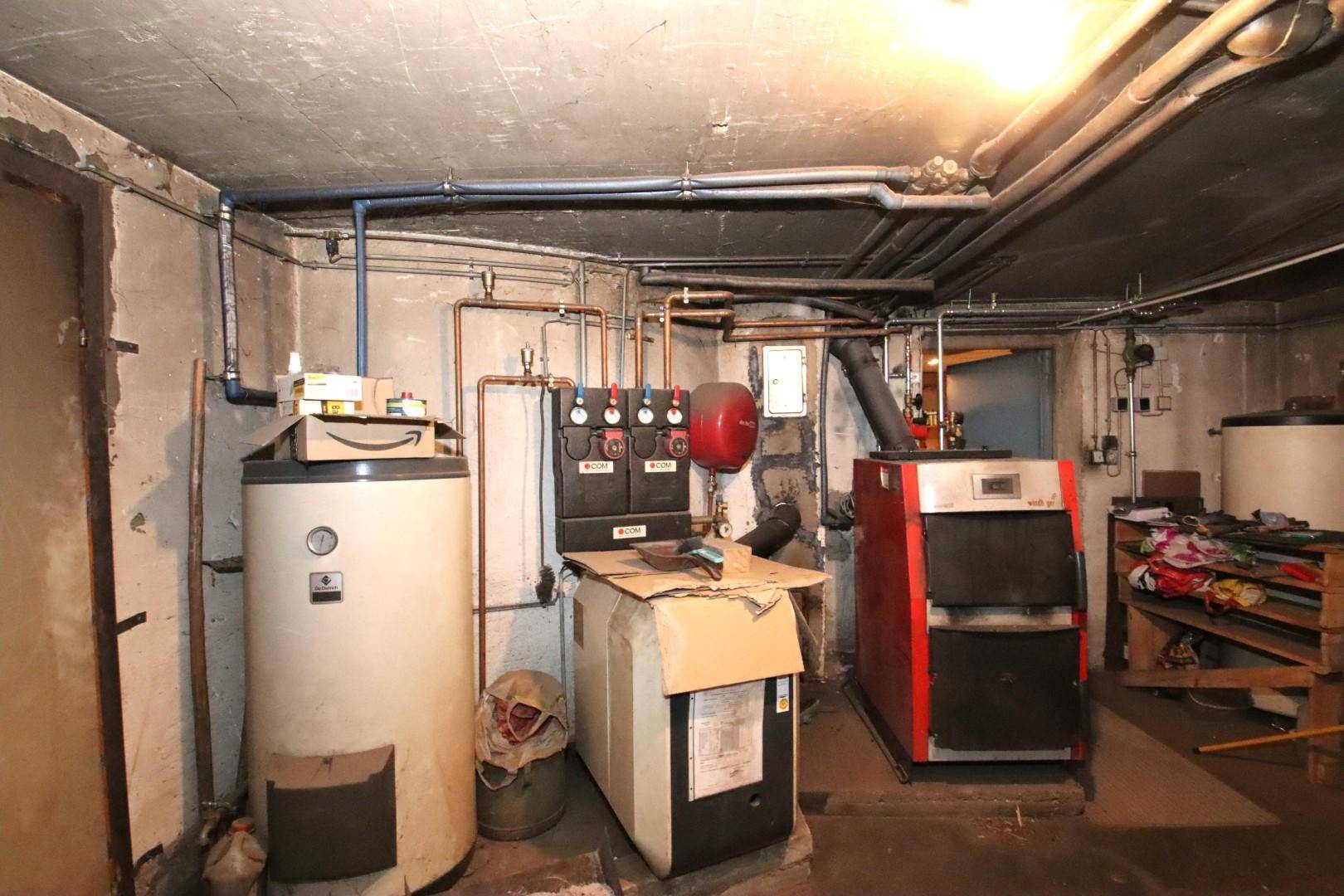 Heizungsraum im Keller mit großem Warmwasserspeicher und zentraler Heizanlage.