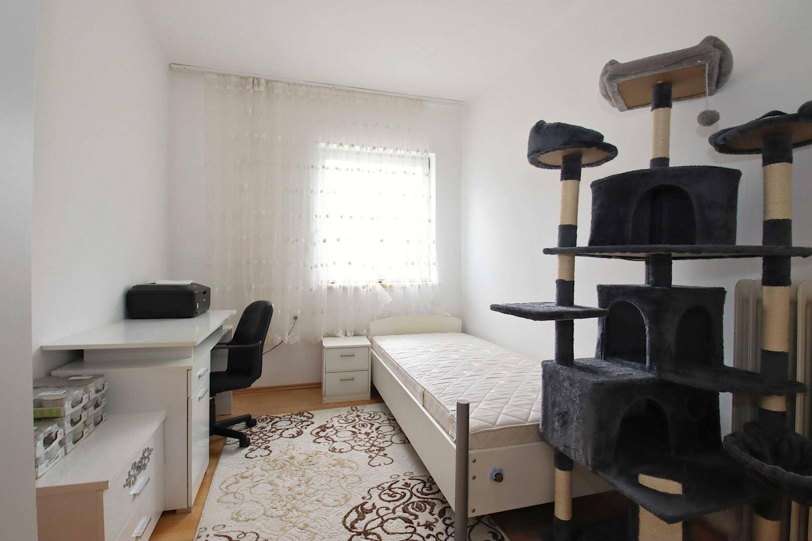 Kinderzimmer oder Gästezimmer mit Einzelbett, Schreibtisch und Katzenbaum.