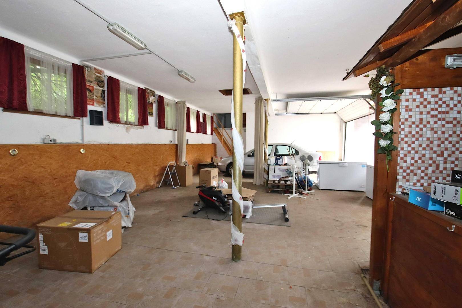 Geräumiger Garagenbereich mit Lagerflächen, Werkzeugen und einem geparkten Auto.