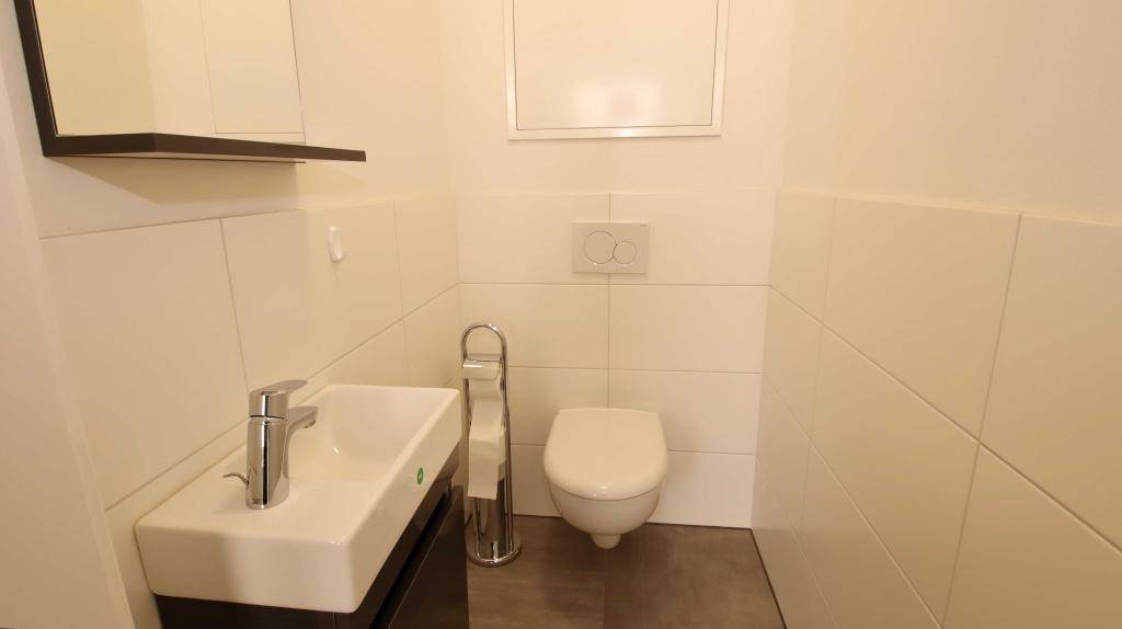 Kleines Gäste-WC mit wandhängender Toilette und modernem Waschbecken.
