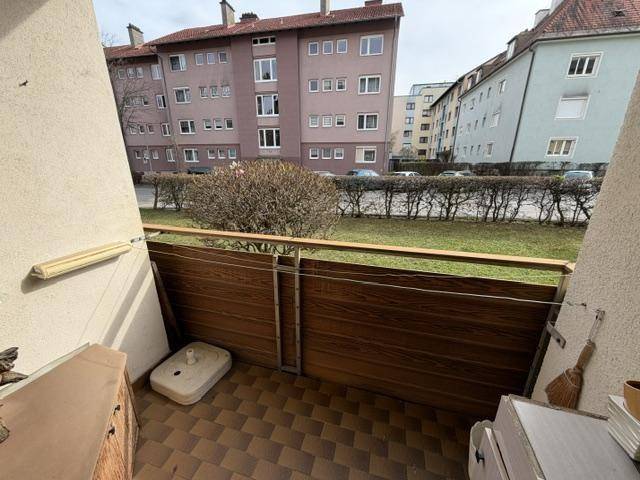 Balkon mit Fliesenboden und Holzverkleidung, bietet einen Blick auf die umliegende Wohngegend.