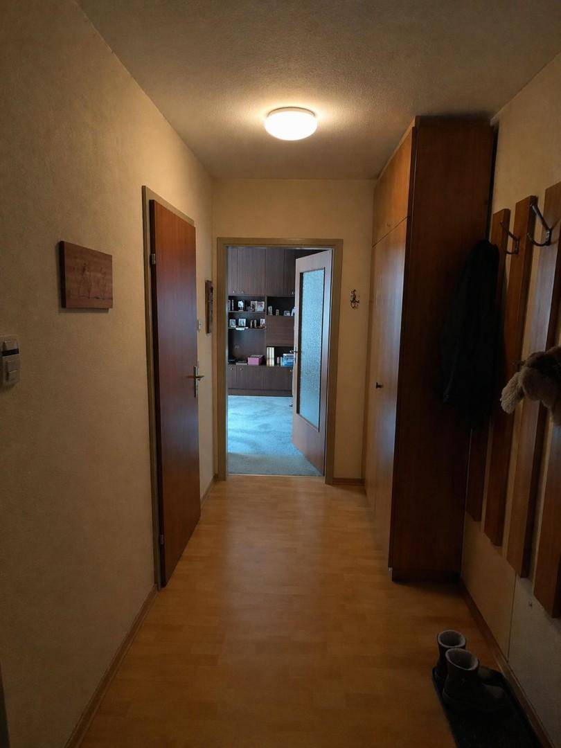Heller Flur mit Laminatboden und Garderobe, der zu den verschiedenen Räumen der Wohnung führt.