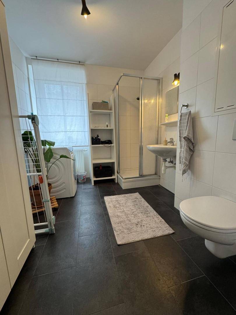 Funktionales Badezimmer mit Toilette, Waschbecken und Duschkabine.