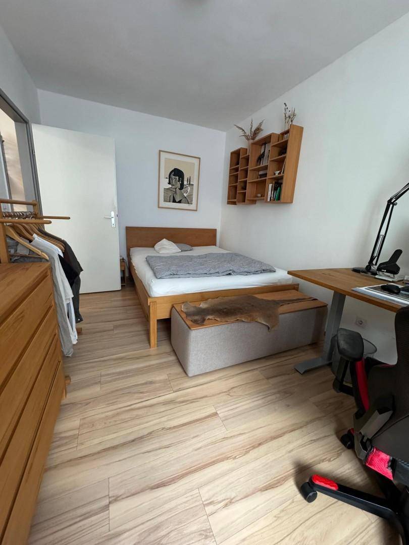 Gemütliches Schlafzimmer mit Holzbett, Schreibtisch und passenden Holzmöbeln.