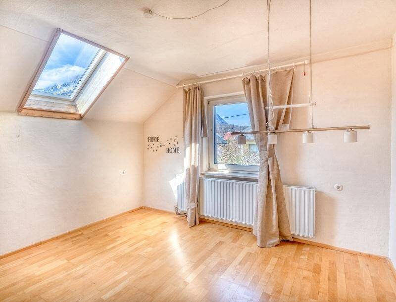 Dachzimmer mit Schrägdach, Dachfenster und hellem Parkettboden.