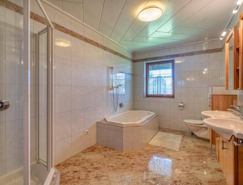 Geräumiges Badezimmer mit Eckbadewanne, separater Dusche und Doppelwaschbecken.