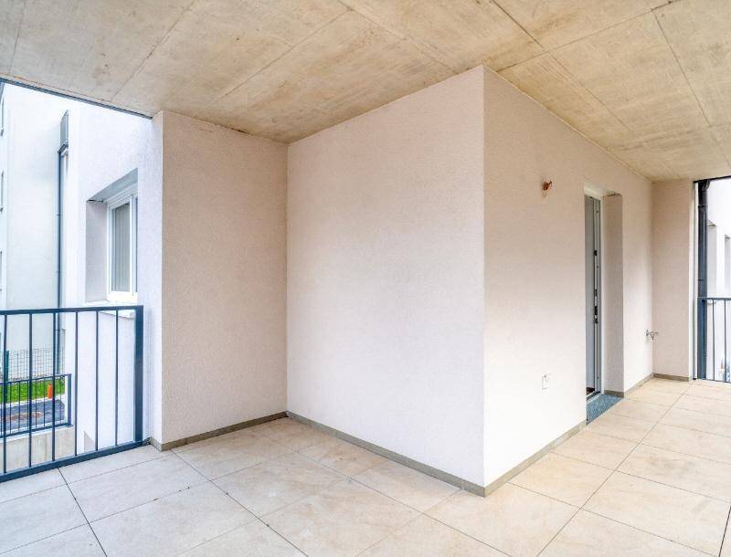 Geräumiger Balkon mit Fliesenboden und Blick auf die umliegenden Gebäude.