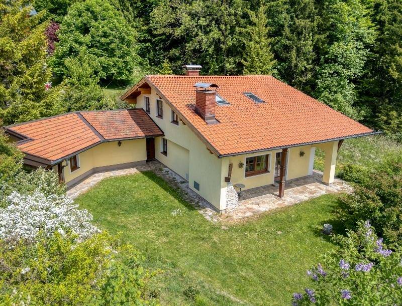 Traditionelles Haus mit Ziegeldach und großem Garten in ländlicher Umgebung.