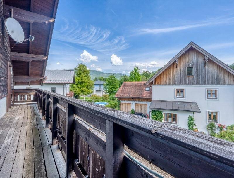 Hölzerner Balkon mit Blick auf die umliegende Landschaft und Nachbarhäuser.