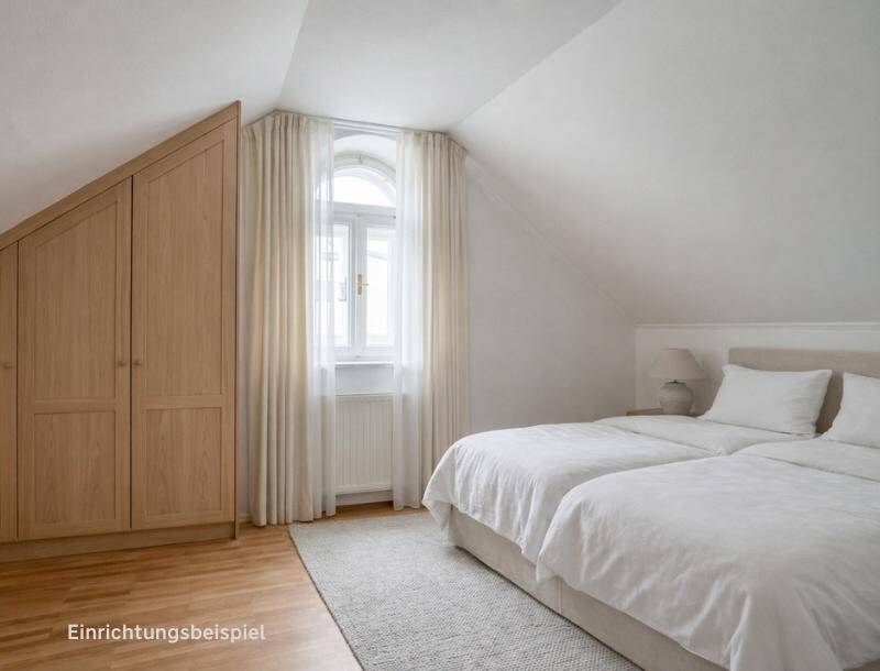 Gemütliches Schlafzimmer mit zwei Betten, Einbauschrank und Dachschräge.