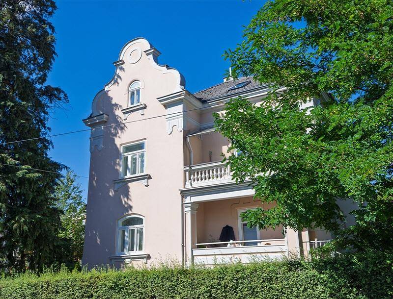 Historische Fassade eines Gebäudes mit dekorativen Elementen und Balkonen.