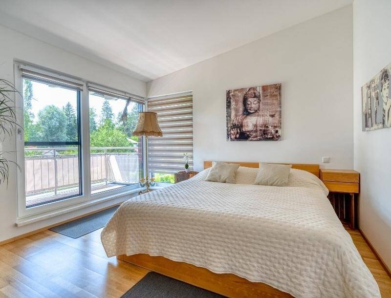 Helles Schlafzimmer mit Doppelbett, Holzboden und direktem Zugang zum Balkon.