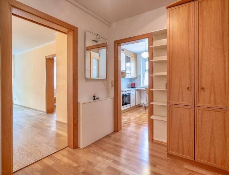 Heller Flur mit Holzfußboden und Zugang zu Küche und weiteren Wohnbereichen.