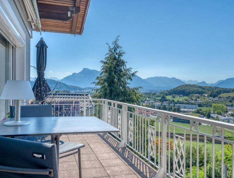 Geräumiger Balkon mit Sitzgelegenheiten und weitem Blick auf die umliegende Berglandschaft und die Stadt.