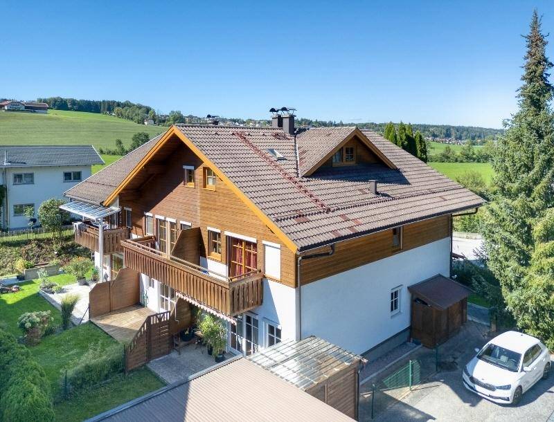 Freistehendes Haus mit Satteldach, Holzfassade und großem Garten in ländlicher Umgebung.
