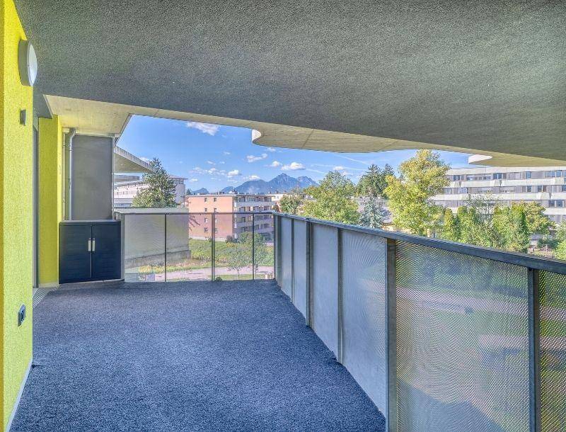 Geräumiger Balkon mit Teppichboden und weitem Blick auf die umliegende Landschaft und Berge.