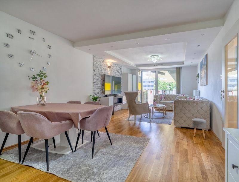 Heller Wohn- und Essbereich mit Holzboden, modernem Dekor und Zugang zum Balkon.