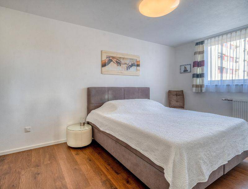 Gemütliches Schlafzimmer mit Holzboden und Fenster mit Blick auf die Umgebung.