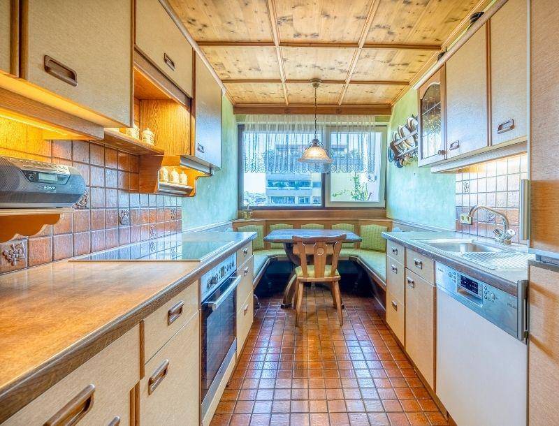 Gemütliche Küche mit integrierter Essecke, Holzdecke und traditionellen Fliesen.