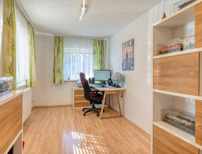 Funktionales Arbeitszimmer mit Schreibtisch, Bürostuhl und Regalen, ideal für Home-Office oder Studium.