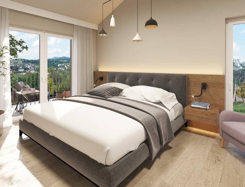 Helles Schlafzimmer mit Balkonzugang, modernem Bett und weitem Blick über die Landschaft.