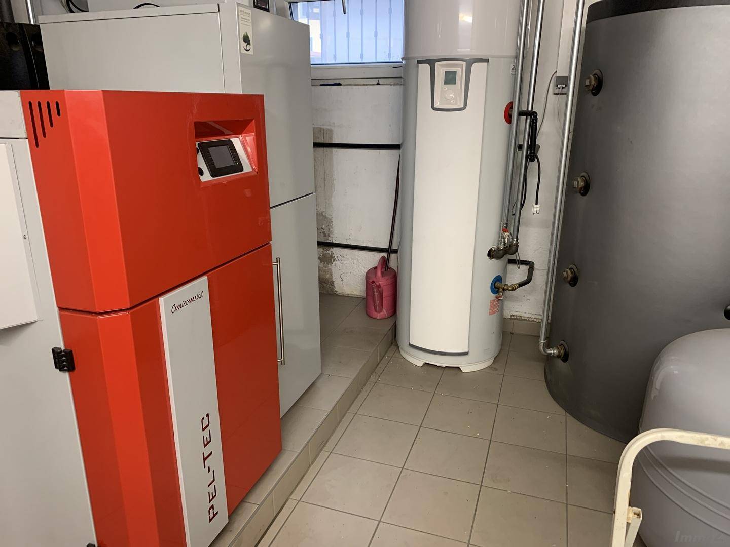 Heizungsraum mit moderner Pelletheizung und Warmwasserspeichern.