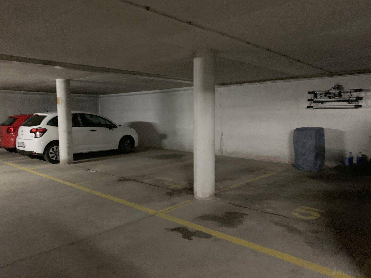 Tiefgarage mit mehreren Stellplätzen und Betonpfeilern für Bewohner.