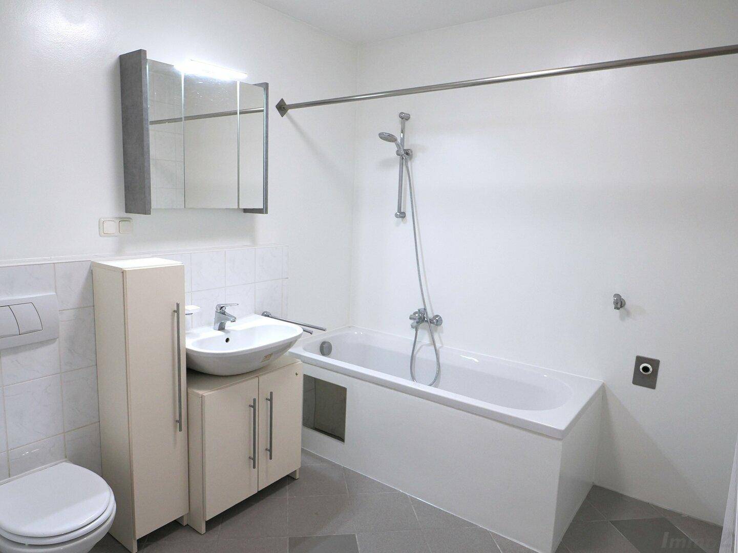 Modernes Badezimmer mit Badewanne, Dusche, WC und Waschbecken mit Unterschrank.