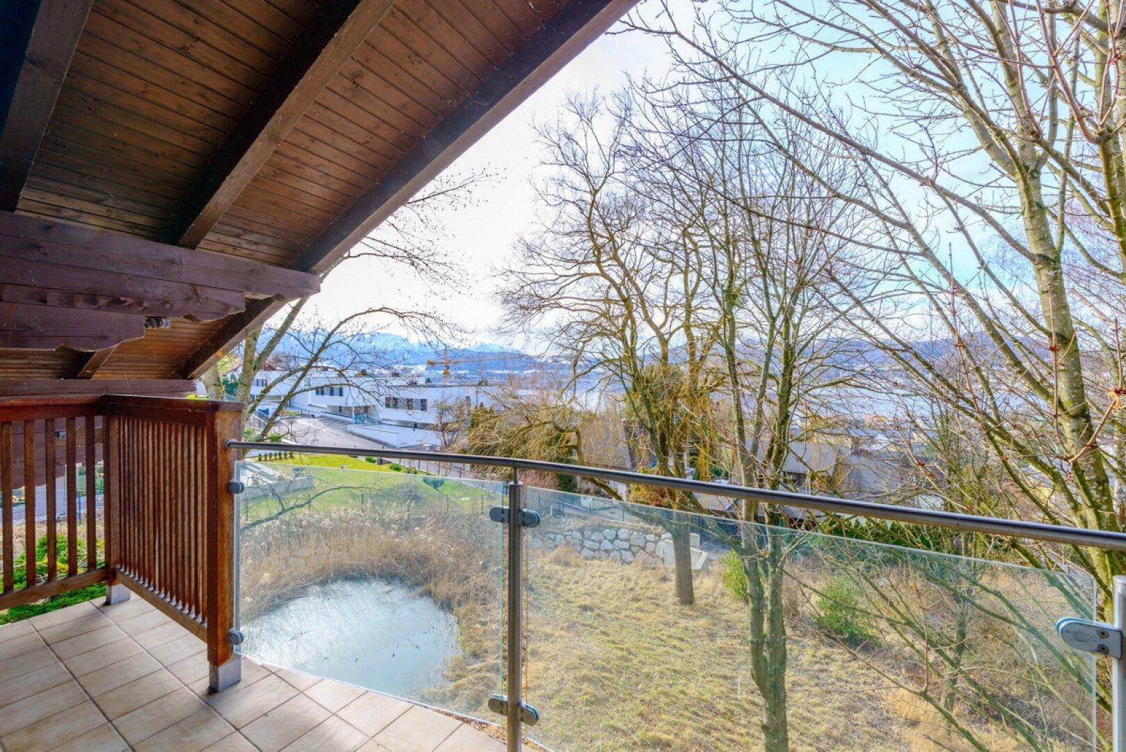 Balkon mit Glasgeländer und weitem Blick über die Stadt und den See.