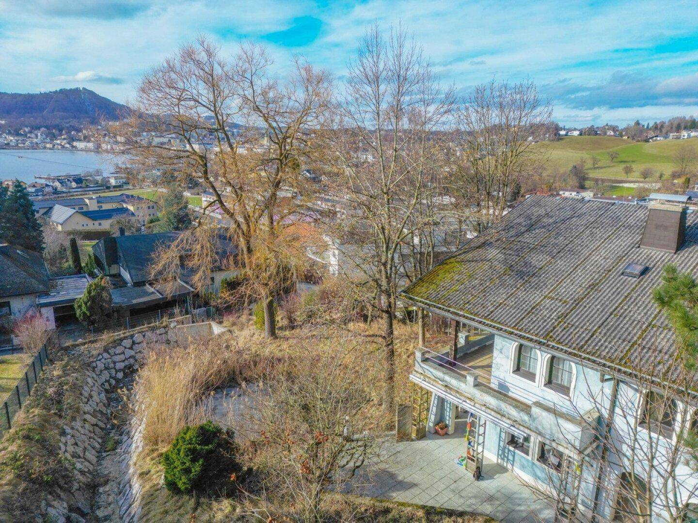 Luftaufnahme des Hauses mit umliegendem Grundstück und Seeblick.