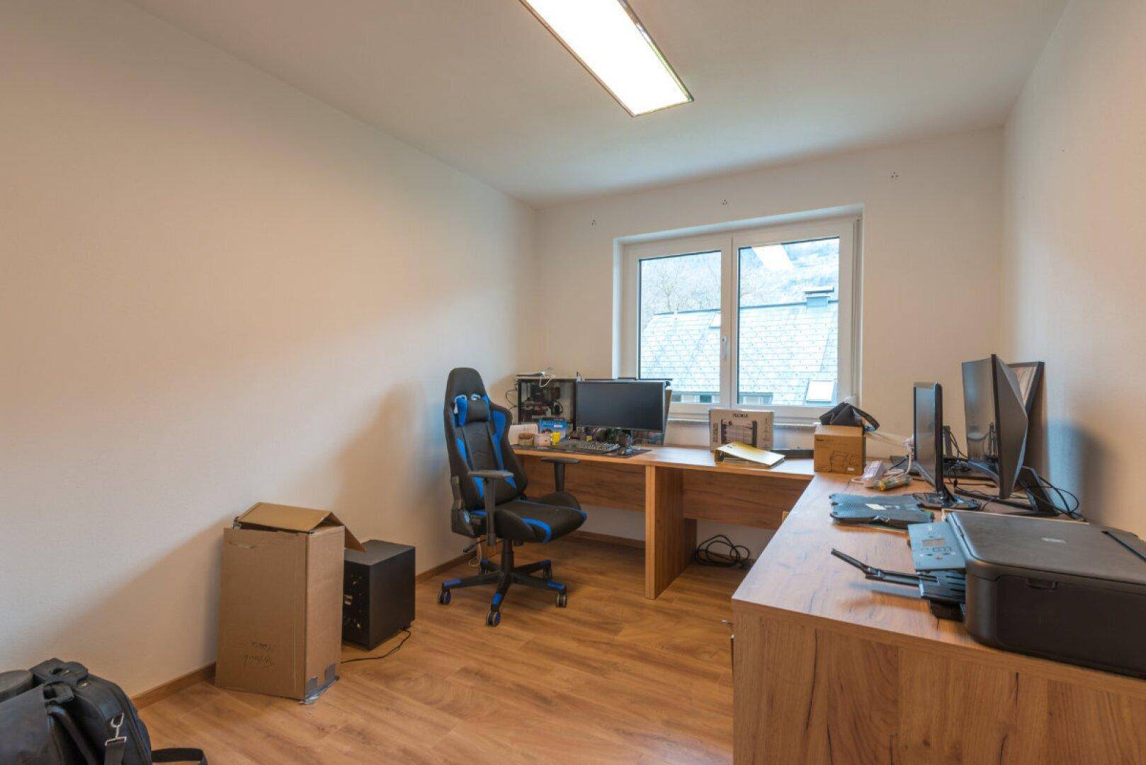 Funktionales Arbeitszimmer mit zwei Schreibtischen, Computerausstattung und Fenster.