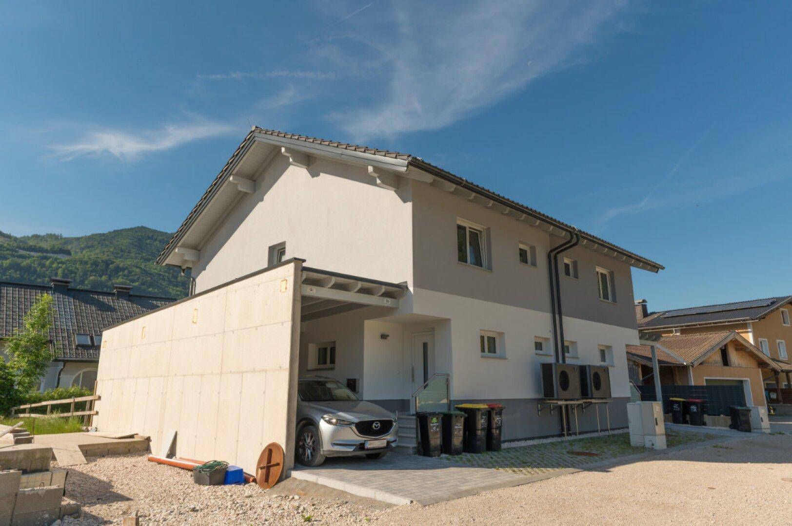 Vorderansicht der Doppelhaushälfte mit Carport und Eingangsbereich.
