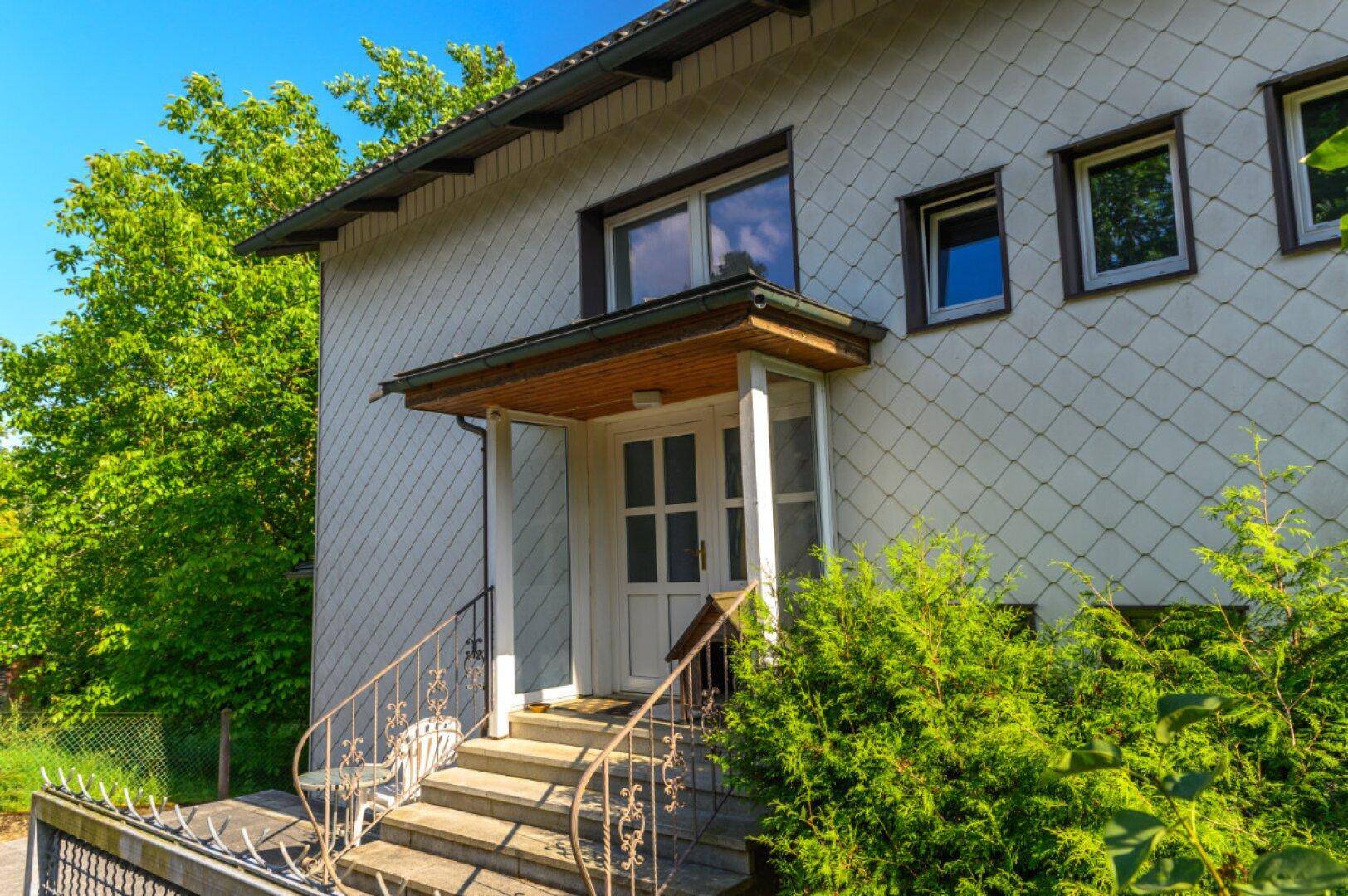 Eingangsbereich des Hauses mit überdachtem Vordach und Treppe.