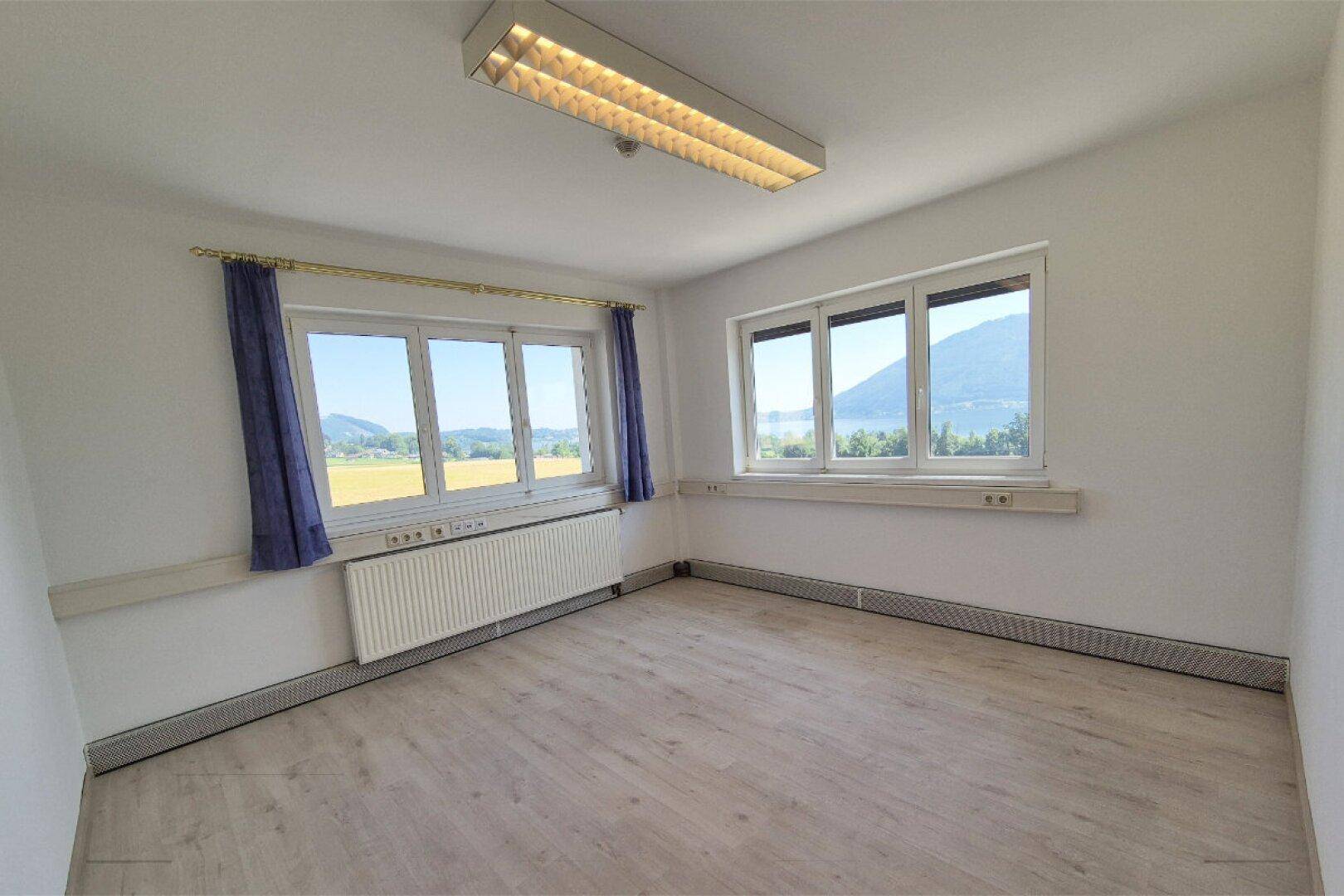Geräumiger Büroraum mit großen Fenstern, die einen weiten Blick auf die Natur bieten.