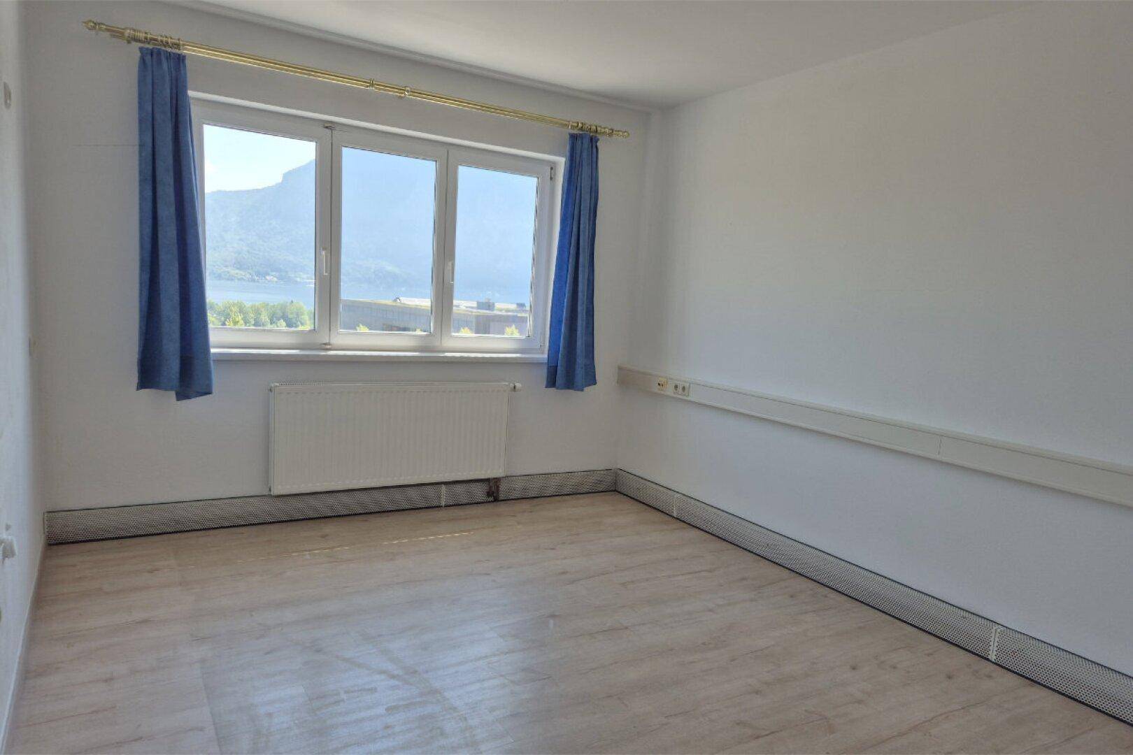 Geräumiges Büro mit großen Fenstern, die einen weiten Blick auf den See und die umliegende Landschaft bieten.