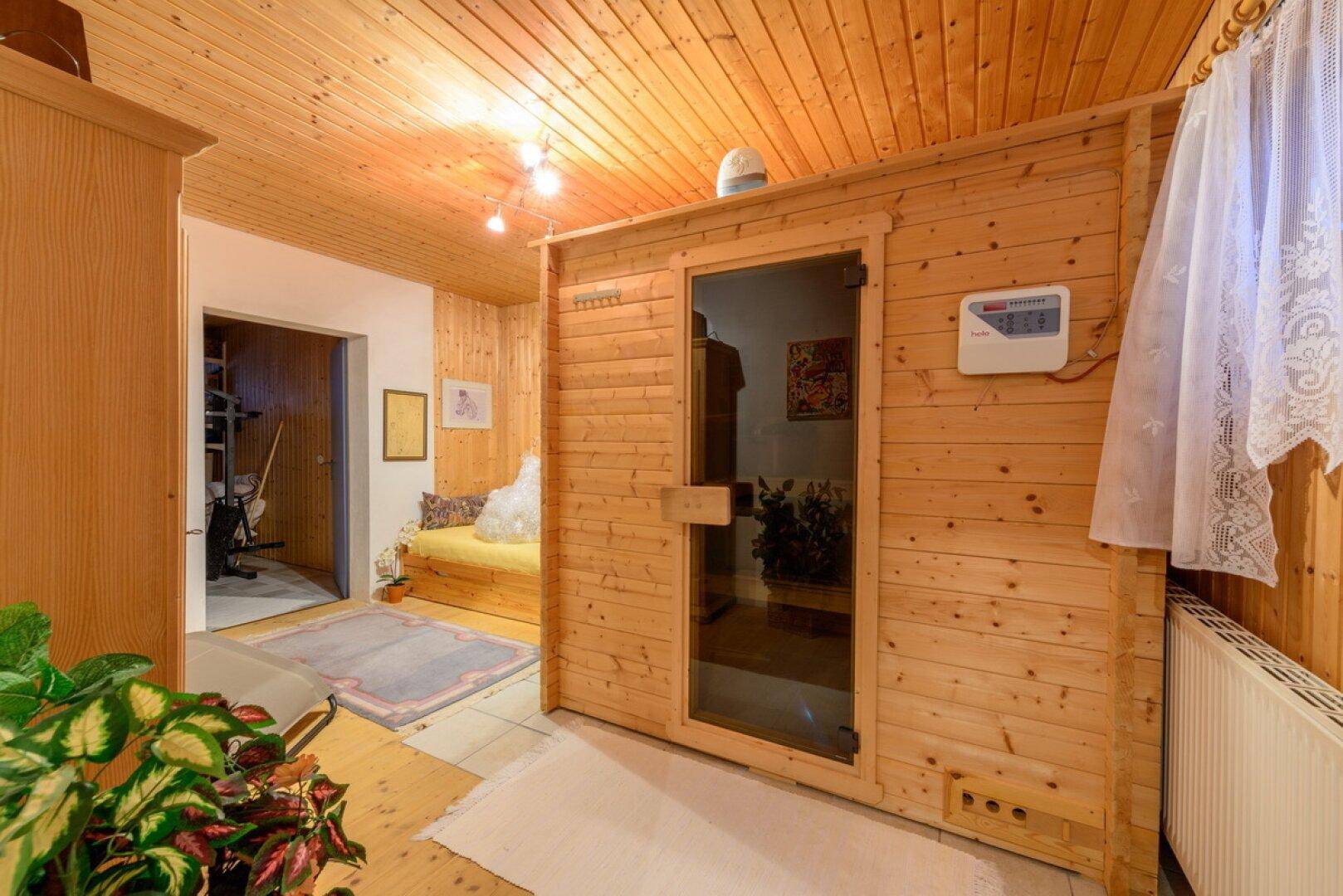 Holzvertäfelte Sauna mit Glastür, ideal zur Entspannung nach einem langen Tag.
