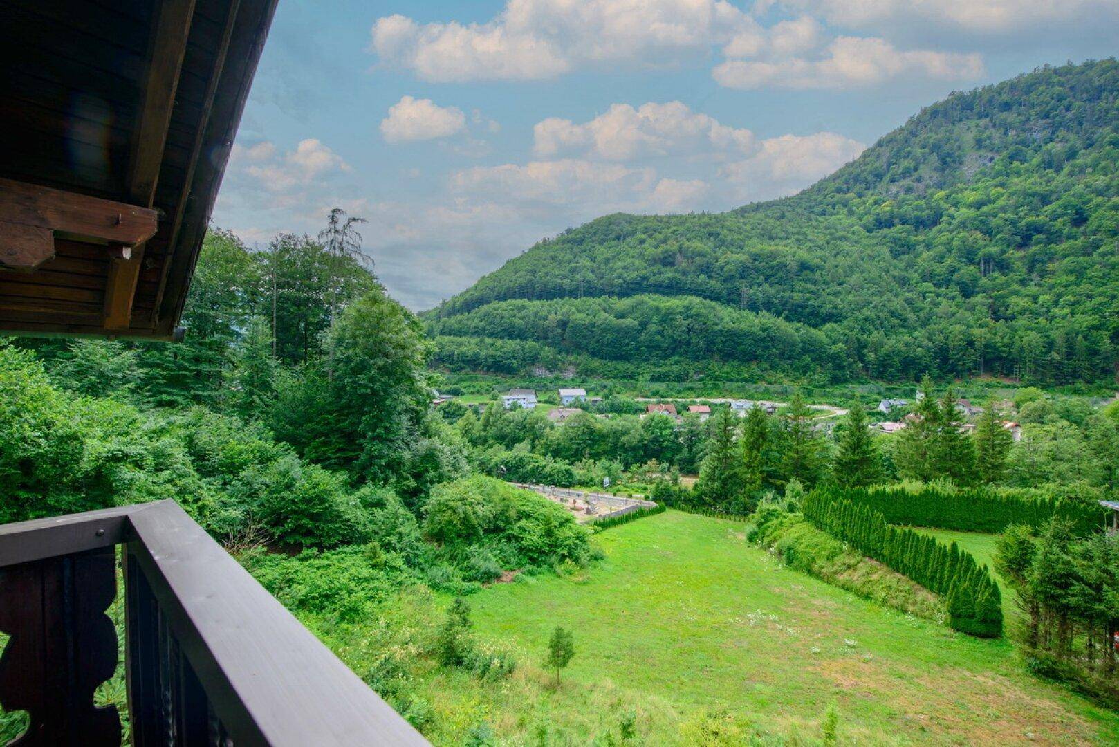 Atemberaubender Ausblick vom Balkon auf die grüne Berglandschaft und das Tal.