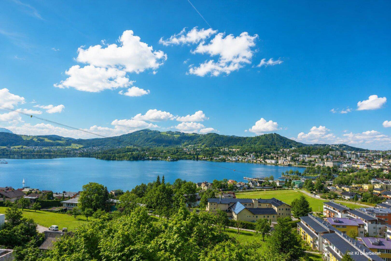 Panoramablick auf die Stadt Gmunden am Traunsee, umgeben von grünen Hügeln und Bergen.