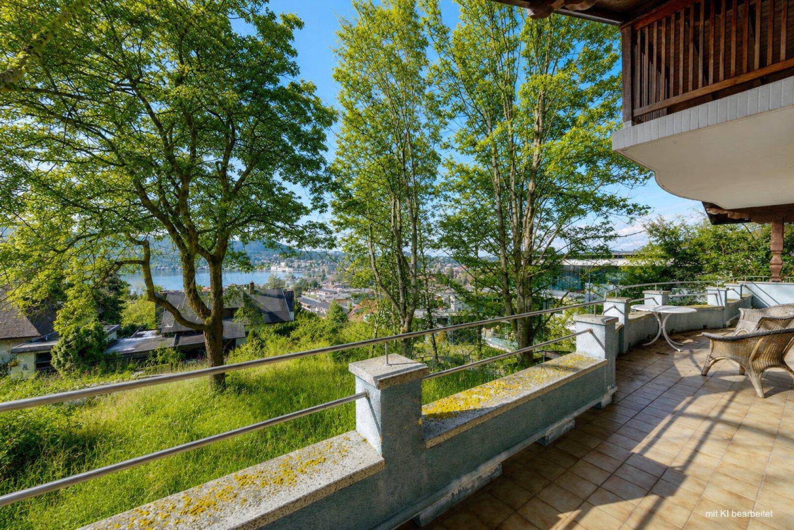 Große Terrasse mit Sitzgelegenheiten und weitem Blick auf den See und die umliegende Landschaft.