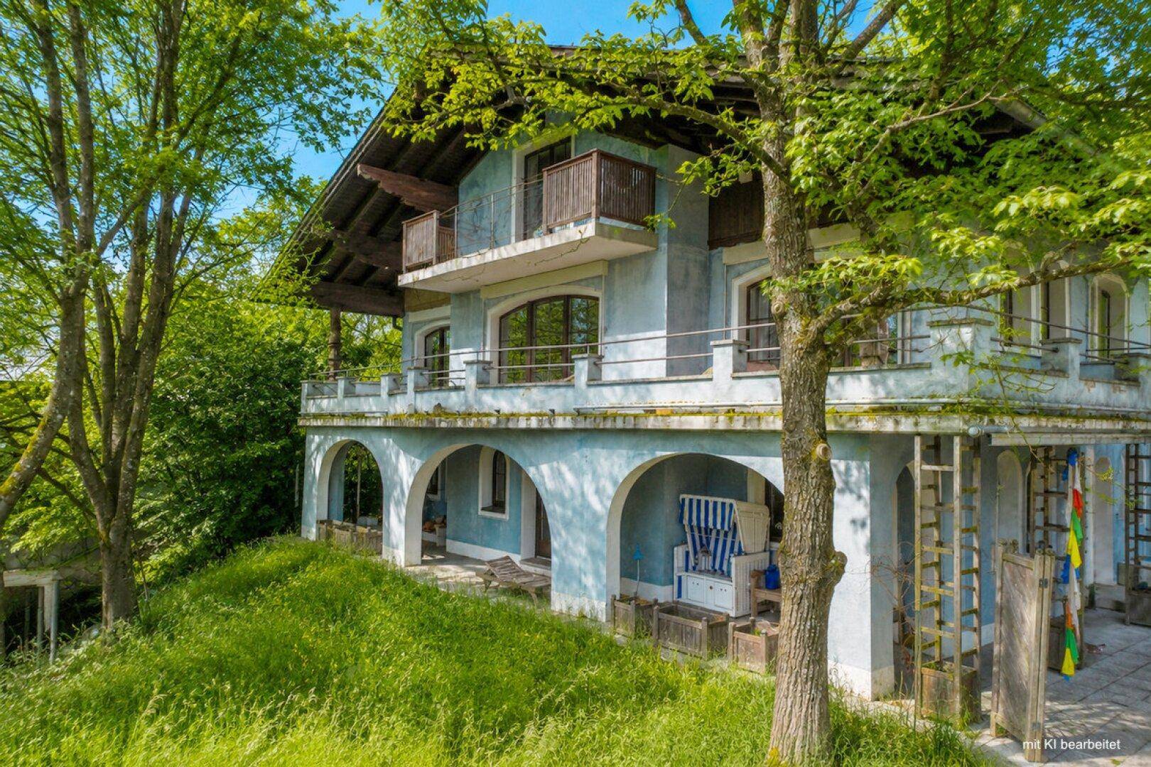 Historisches Wohnhaus mit hellblauer Fassade, mehreren Balkonen und Arkaden im Erdgeschoss.